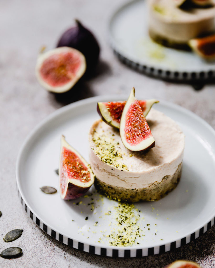 roh-veganer kuchen mit kürbiskernboden und zitronencreme, getoppt mit frischen feigen