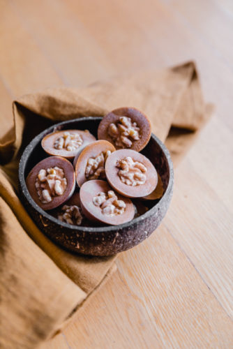 Gefrorene Kürbis Schoko Bites mit Walnüssen in einer Kokosschale