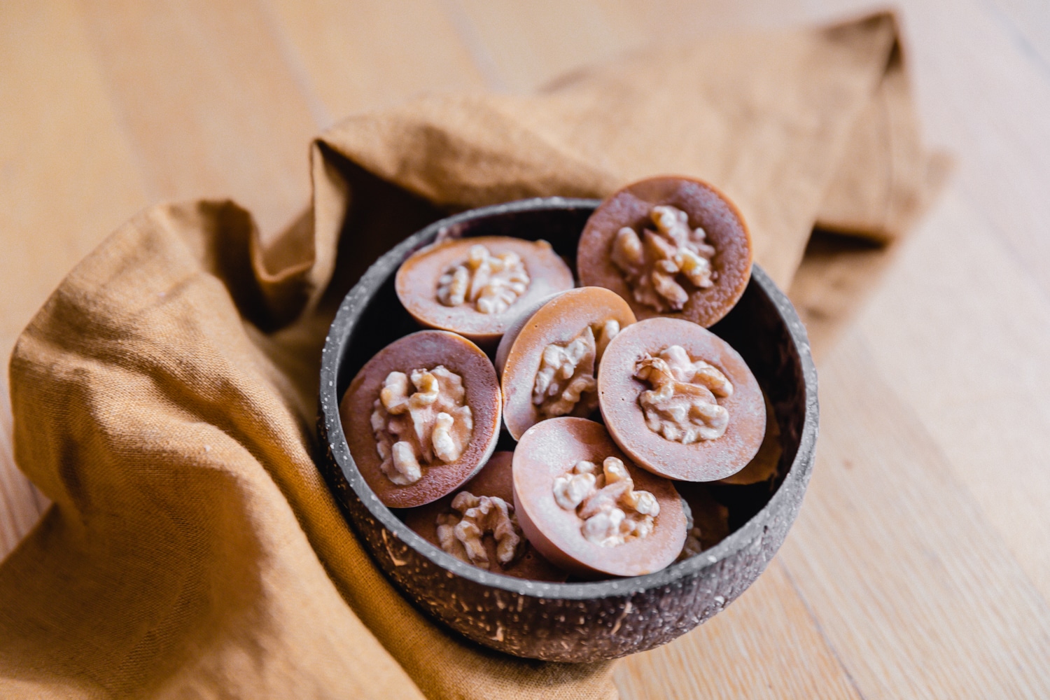 Gefrorene Kürbis Schoko Bites mit Walnüssen in einer Kokosschale